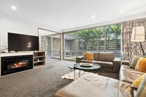a living room with a couch and a fireplace at Central Location - Contemporary 2 Bedroom Aptm in Queenstown