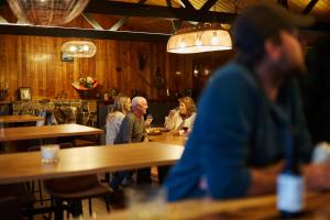 a group of people sitting at tables in a restaurant at River Run Lodge in Strathblane