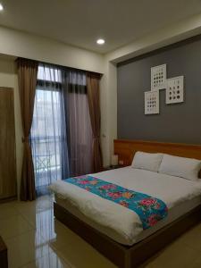 a bedroom with a large bed and a large window at Tung Shiang Homestay in Sanyi