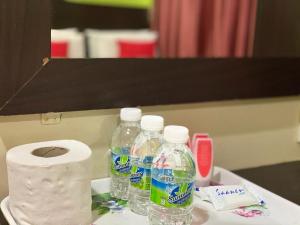 two bottles of water and a roll of toilet paper at Ct Hotel in Sitiawan