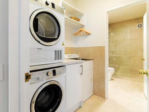 a washer and dryer in a bathroom with a toilet at Central Location - 2 Bedroom Apartment in Habeke in Queenstown