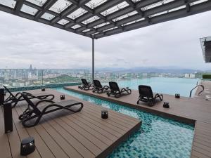 a swimming pool with chairs on a roof at Eko Cheras Residences by De Space in Kuala Lumpur