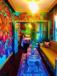Serendipity Lake Artistic Bungalow by Heidis Home في نوارا إليا: غرفة معيشة مع أريكة وجدار ملون