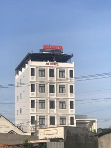 a white building with a sign on top of it at An Hotel Phan Thiết in Phan Thiet