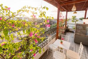 a balcony with white chairs and pink flowers at Hoang Trinh Hotel in Hoi An