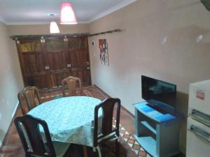 een kleine eetkamer met een tafel en een televisie bij Amancay in Tandil