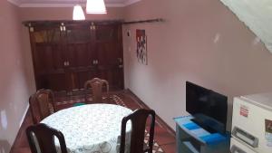 een eetkamer met een tafel en een televisie bij Amancay in Tandil +1 foto