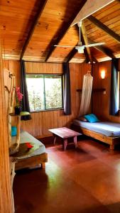 a room with two beds and a table in a cabin at Eco Lodge Village Temanoha in Paopao