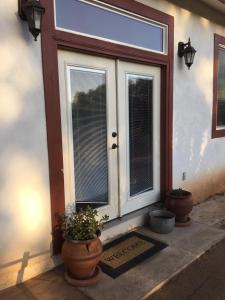 a front door of a house with potted plants next to it at Beautiful new detached casita nestled in scenic southern CA foothills! in Fallbrook