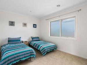 2 camas en una habitación con ventana en Rosebay Walk To The Foreshore, en Capel Sound