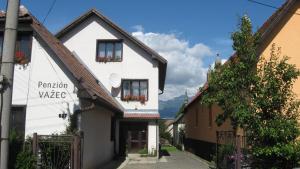 a white building with flower boxes on the windows at Penzion Važec in Važec