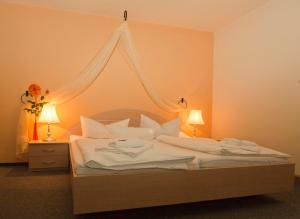 a bedroom with a bed with white sheets and pillows at Hotel am Galgenberg in Gera