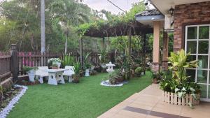 un patio trasero con mesa, sillas y plantas en SMART Homestay Permaipura en Sungai Petani