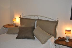 1 dormitorio con 1 cama con almohadas y 2 lámparas en Chic & Country, en Lecce