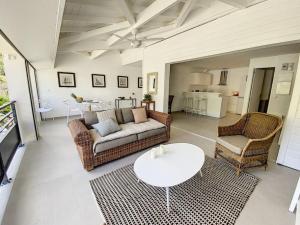 ein Wohnzimmer mit einem Sofa, 2 Stühlen und einem Tisch in der Unterkunft Acacia Marina, luxurious Duplex, walkable beach in Anse Marcel 