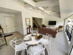 een woonkamer met een tafel en stoelen en een bank bij Acacia Marina, luxurious Duplex, walkable beach in Anse Marcel 