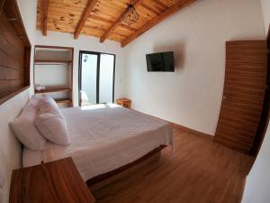 a bedroom with a bed and a tv on the wall at Real Carretero in Tapalpa