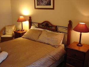 um quarto com uma cama, 2 candeeiros e uma cadeira em Truro weighbridge motel em Stockwell