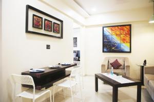 uma sala de estar com uma mesa e cadeiras e um sofá em Lite Stays - Vile Parle East em Mumbai