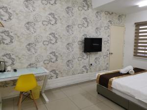 1 dormitorio con 1 cama, escritorio y TV en Melaka Stay, en Melaka