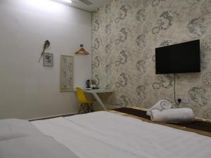 1 dormitorio con 1 cama y TV de pantalla plana en Melaka Stay, en Melaka