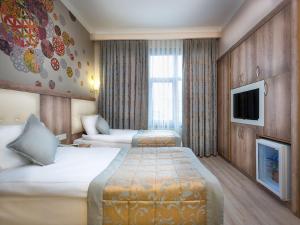 a hotel room with two beds and a tv at Fatih Hotel Corner in Istanbul
