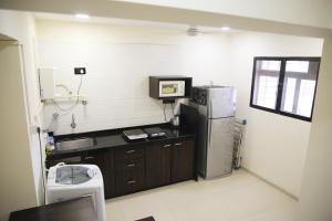a kitchen with a black counter and a refrigerator at Lite Stays - Vile Parle East in Mumbai +54 photos