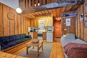 ein Wohnzimmer mit einem Sofa und einer Küche in der Unterkunft Ski-inn kelohuoneisto Pyhätunturissa in Pelkosenniemi