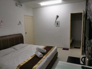 Un dormitorio con una cama con una toalla. en Melaka Stay, en Melaka