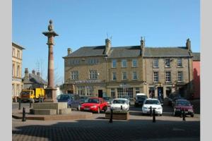 a street with cars parked in front of a building at Duns Guest Rooms in Duns