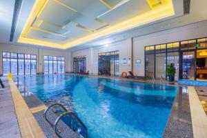 a large swimming pool with blue water in a building at Holiday Inn Resort Chaohu Hot Spring, an IHG Hotel in Chaohu