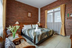 a bedroom with a bed and a brick wall at Sekararum Butik Syariah Guesthouse in Bandung