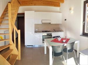 uma cozinha com uma mesa e cadeiras e uma escadaria em La Quiete 58 Maisonette Lake view by Gardadomusmea em Pieve