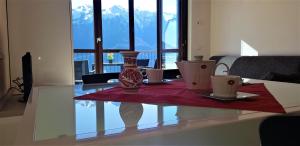 uma sala de estar com uma mesa com dois vasos em La Quiete 58 Maisonette Lake view by Gardadomusmea em Pieve