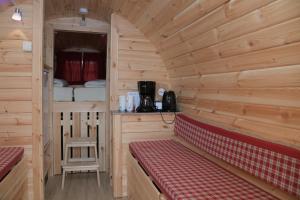 une cabane en rondins avec un banc rouge dans une pièce dans l'établissement Barrels am Clerve, à Enscherange