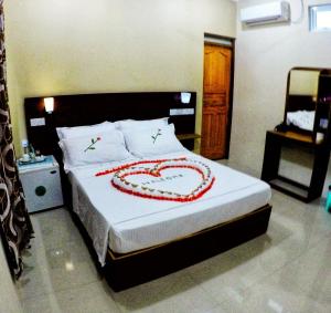 a bedroom with a bed with a heart drawn on it at Sunset Beach View in Dhangethi