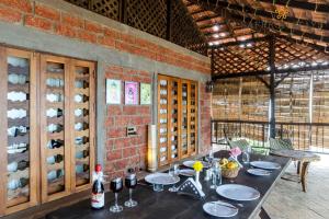 a dining room with a table with plates and wine bottles at SaffronStays Villa 270, Dapoli in Dapoli