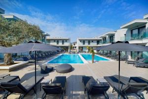 a pool at a hotel with chairs and umbrellas at Daria Essence in Limenas