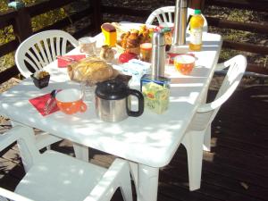 una mesa blanca con comida y bebidas. en B&B La Douloire, en Pernes-les-Fontaines