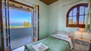 a bedroom with a bed and a view of the ocean at Villa Angela, seafront apartments, Almiros beach in Almiros Beach