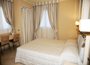 a bedroom with a bed and a desk and window at La Casa di Gino in San Nicola