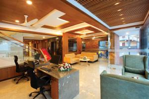 an office with a desk with a laptop and chairs at HOTEL AMALA in Pathanāmthitta