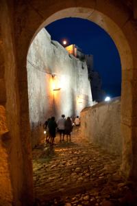 a group of people walking down an alley at night at La Casa di Gino in San Nicola