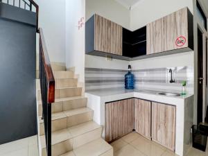 a kitchen with a staircase with a sink and a sink at OYO 90215 Ada Residence in Poponcal 2