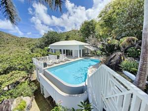 a swimming pool with chairs and a house at Villa Casa Sand, luxury, 5 min walk from Anse Marcel beach in Anse Marcel 