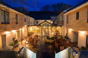 an outdoor patio with tables and chairs at night at The Three Crowns in Chagford