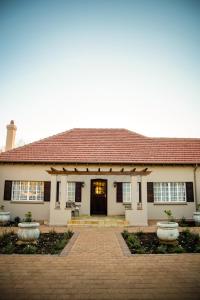 Casa blanca con techo rojo en Abiento Guesthouse, en Bloemfontein