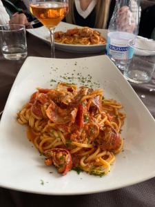 a plate of pasta with shrimp on a table at Hotel Virgilio in Taranto