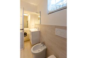 Un baño blanco con inodoro y lavabo. en AL RIFUGIO DI SAN MASSIMO RAPALLO, Air Conditioning, WiFi, Beautiful Studio with Terrace Surrounded by Nature in Rapallo, en Rapallo 18 fotos más