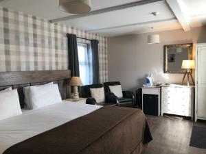 a hotel room with a bed and a desk and chairs at The Cross Guest House in Mablethorpe